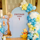 Soft macaron balloons finish the playful setup.