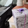 A surprise box packed with a purple ribbon.