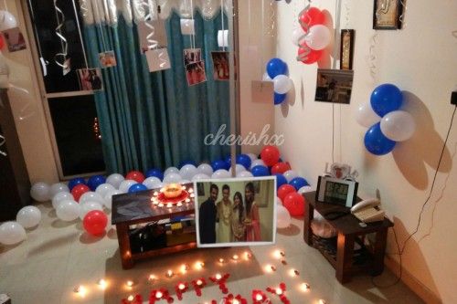 Room decoration with colourful balloons spread out on the floor and photos hanging from the ceiling available in Bangalore.