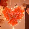 A heart made up of lights and red-coloured balloons for the room decoration.