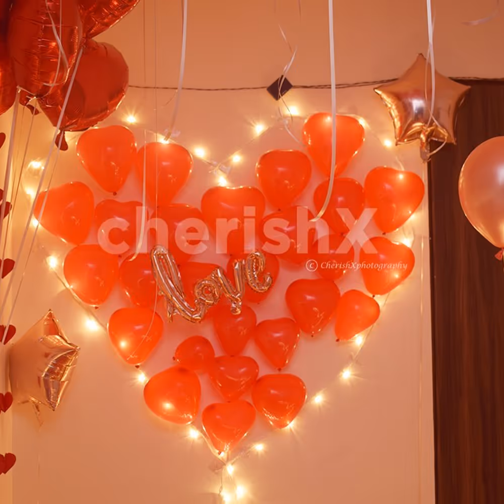 A heart made up of lights and red-coloured balloons for the room decoration.
