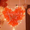 A heart made up of lights and red-coloured balloons for the room decoration.