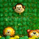 The wall is covered with green balloons for giving the look of the Lion King Movie.