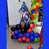 A Captain America Cut-out on a balloon bunch stand.