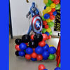 A Captain America Cut-out on a balloon bunch stand.