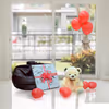A Teddy Surplosion Box with a gift, teddy and balloons.