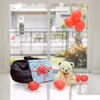 A Teddy Surplosion Box with a gift, teddy and balloons.