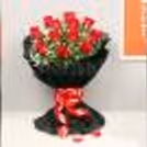 Roses in a black paper packaging with a black forest cake delivered at home
