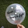 A helium confetti balloon with a 'never sleep over a fight' vinyl message.