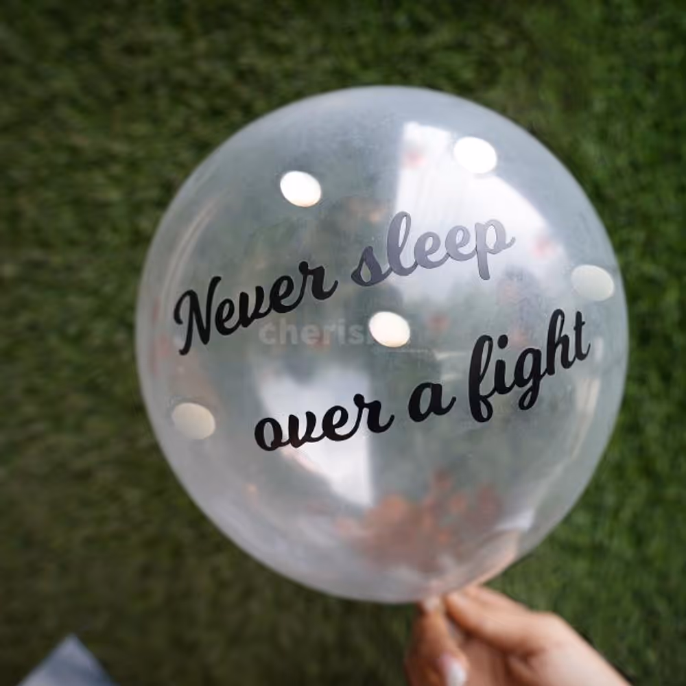 A helium confetti balloon with a 'never sleep over a fight' vinyl message.