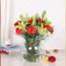 Elegant yellow lilies and red carnations decor in a fish bowl, ideal for birthdays and anniversary celebrations.