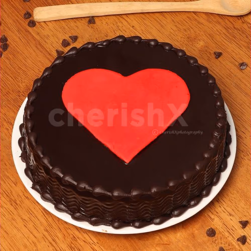 A chocolate flavoured cake with a heart on the top.