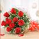 A bouquet of red roses packed with a cellophane sheet.