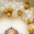 An arch made of white and golden balloons, giving the decor a brighter look.