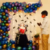 An arch created with Green, blue, purple, golden, and metallic blue balloons for Ganesh Chaturthi peacock themed decor!