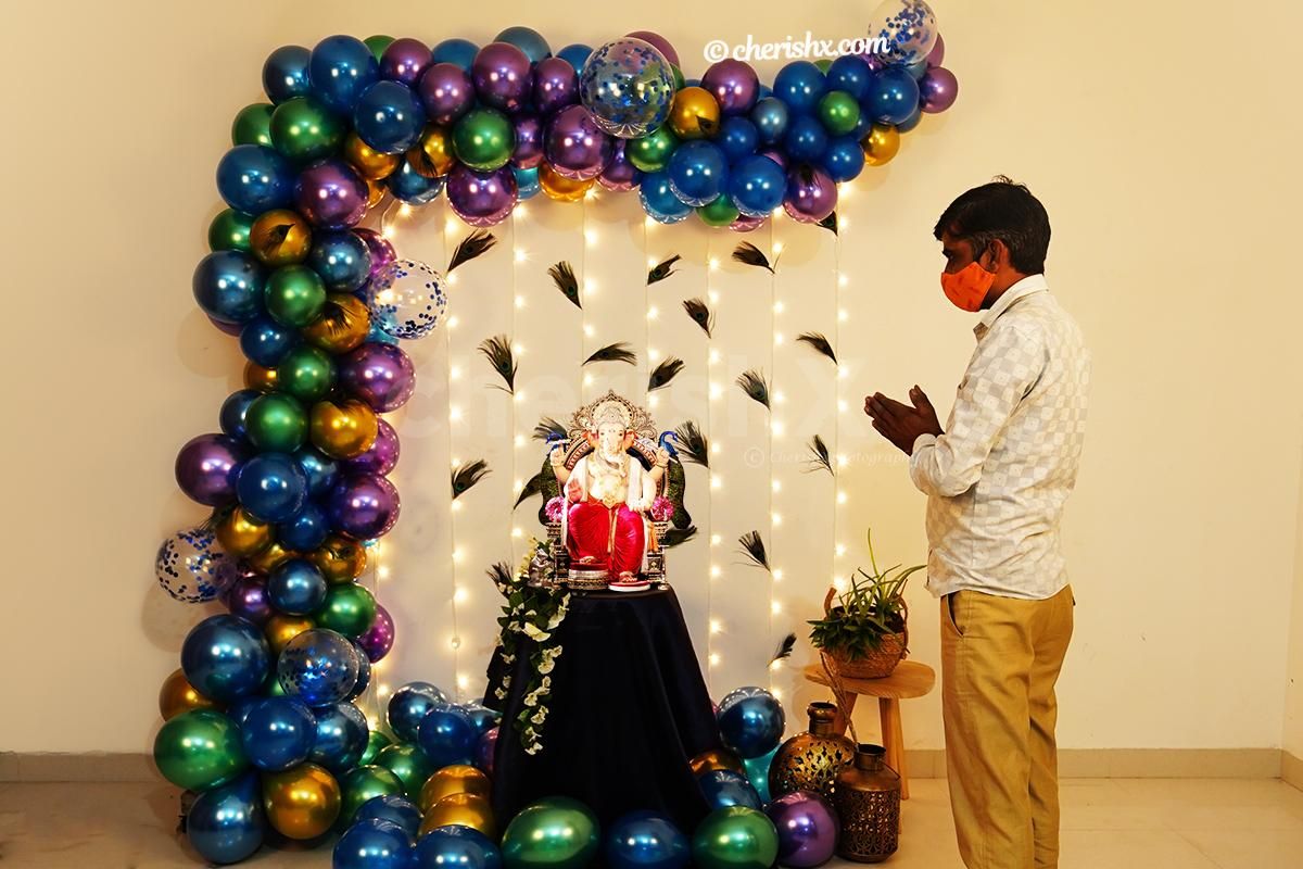 An arch created with Green, blue, purple, golden, and metallic blue balloons for Ganesh Chaturthi peacock themed decor!