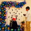 An arch created with Green, blue, purple, golden, and metallic blue balloons for Ganesh Chaturthi peacock themed decor!