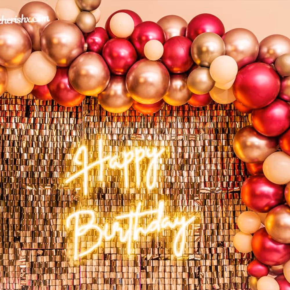 A wall covered with an arc of silver and pink chrome balloons.