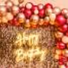 A wall covered with an arc of silver and pink chrome balloons.