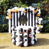 The Black and Golden Decor includes this table decorated with White Latex and Black Latex balloons placed with Black and white strips backdrop.