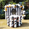 The Black and Golden Decor includes this table decorated with White Latex and Black Latex balloons placed with Black and white strips backdrop.