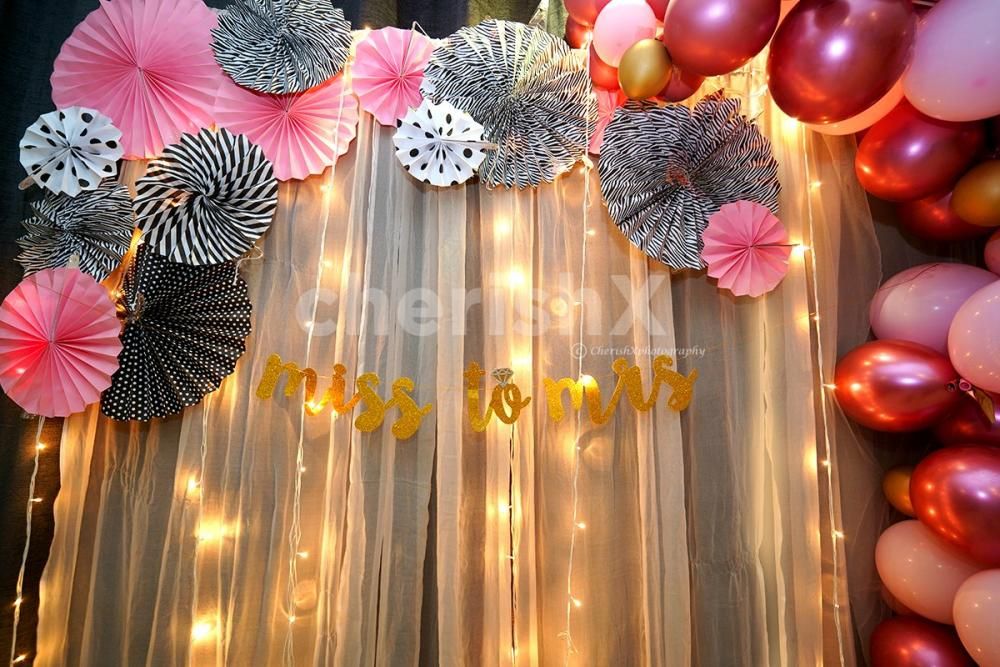 Rosettes of Pink, White and Gray Coloured used to make the room decoration brighter.