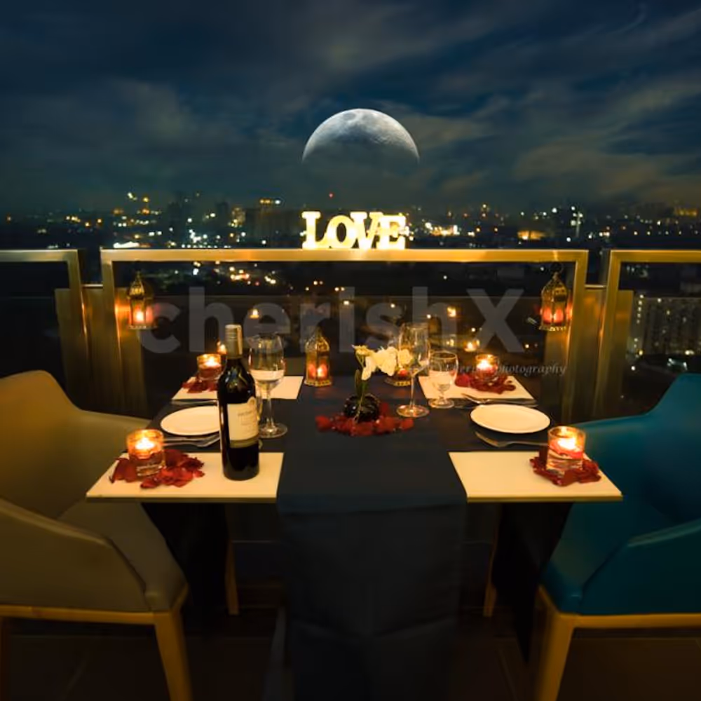 A Romantic Candle Light Dinner table decorated with Rose petals and candles.