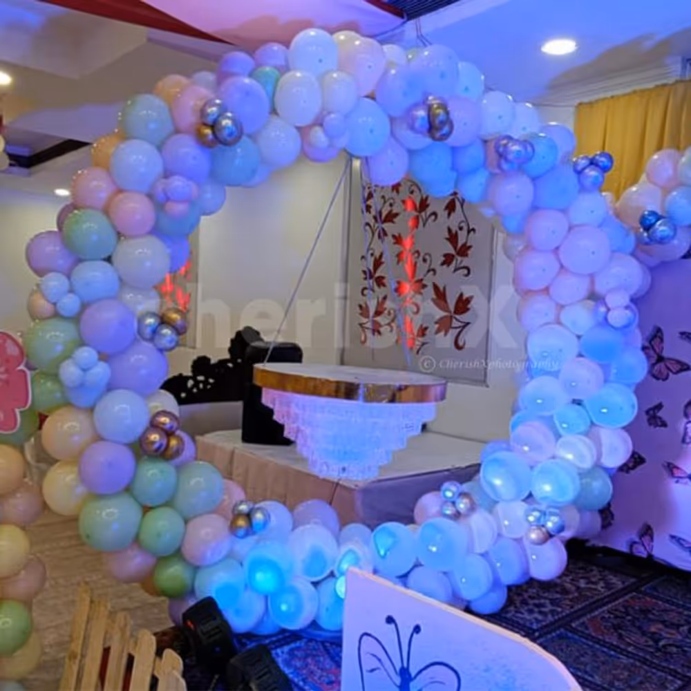 Modern elements of paper cuts, balloon arch, and sun board cutouts for an enhanced birthday experience