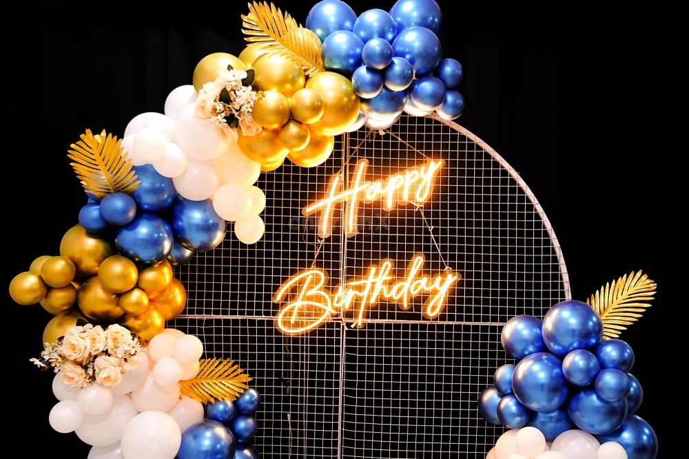 Celebrate surrounded by the royal balloon backdrop adorned with a blend of Golden Chrome, Blue chrome and White Latex.