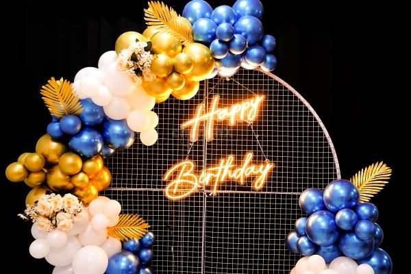 Celebrate surrounded by the royal balloon backdrop adorned with a blend of Golden Chrome, Blue chrome and White Latex.