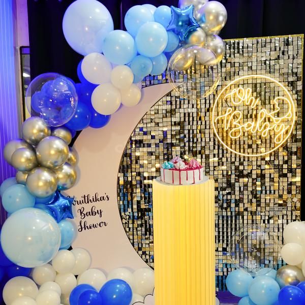 The delicate pastel blue and silver chrome balloons create a celestial atmosphere that is both soothing and magical.