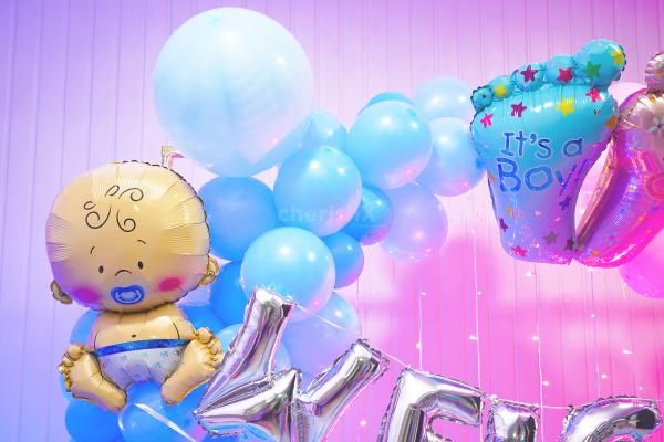 Magical moments are captured in one frame! The sun board adorned with blue and pink balloon decorations sets the stage for a memorable welcome baby celebration.