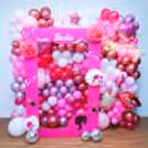 Light pink heart foil balloons, small star foil balloons, a lipstick foil balloon, and a kiss me foil balloon add a dash of glamour