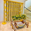 A gold-coloured backdrop adorned with 11 rows of marigold yellow and lily flowers, creates a captivating and visually striking centrepiece.