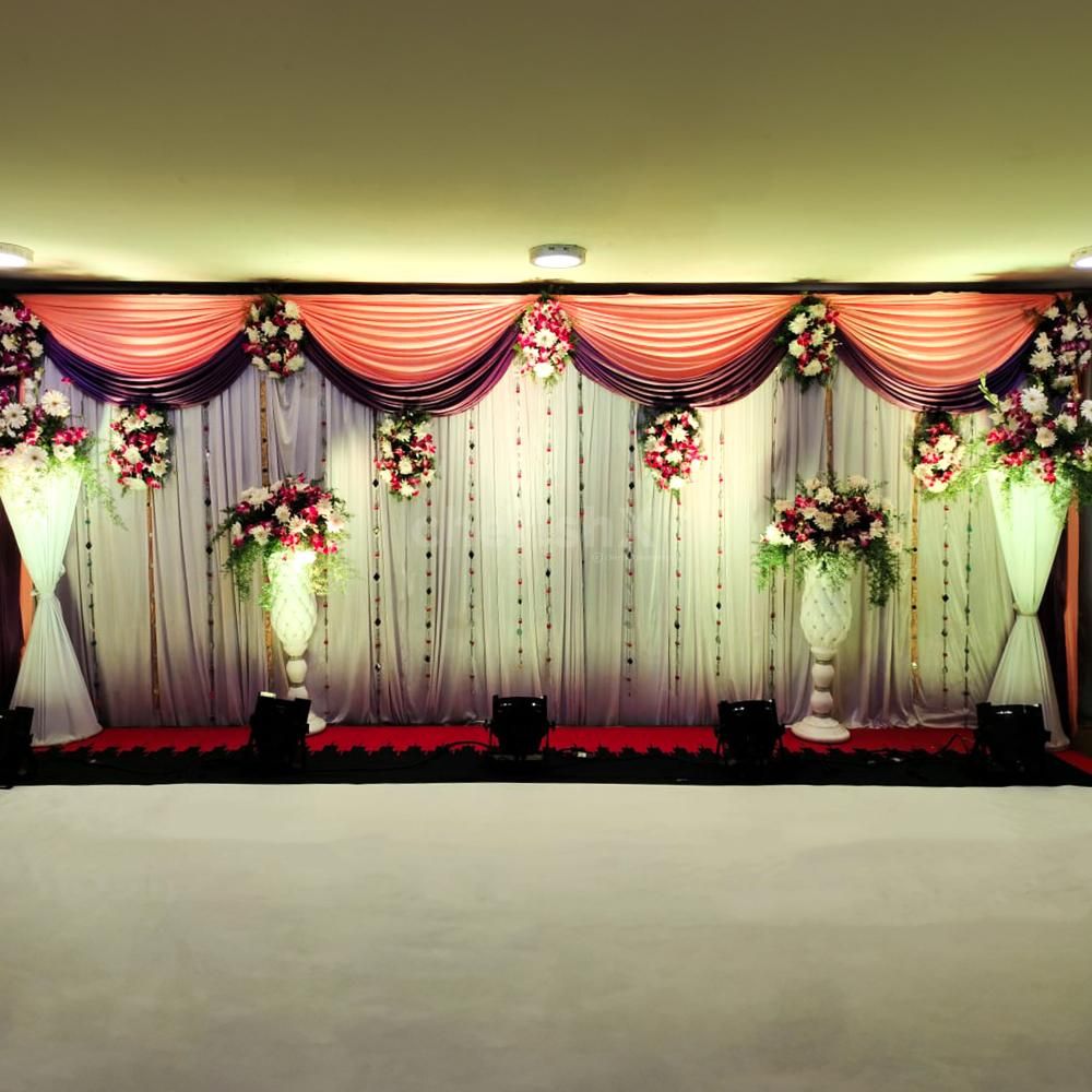 Embrace the charm of nature with fresh krishantham, arcades, and white daisy flowers, gracefully arranged on the stage backdrop.