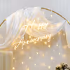 Experience the magic of our heartwarming ring floral backdrop adorned in warm-glowy pixel lights.
