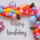 Elevate the Celebration with a Balloon Arch Bursting with Yellow, Blue, and Magenta Hues.