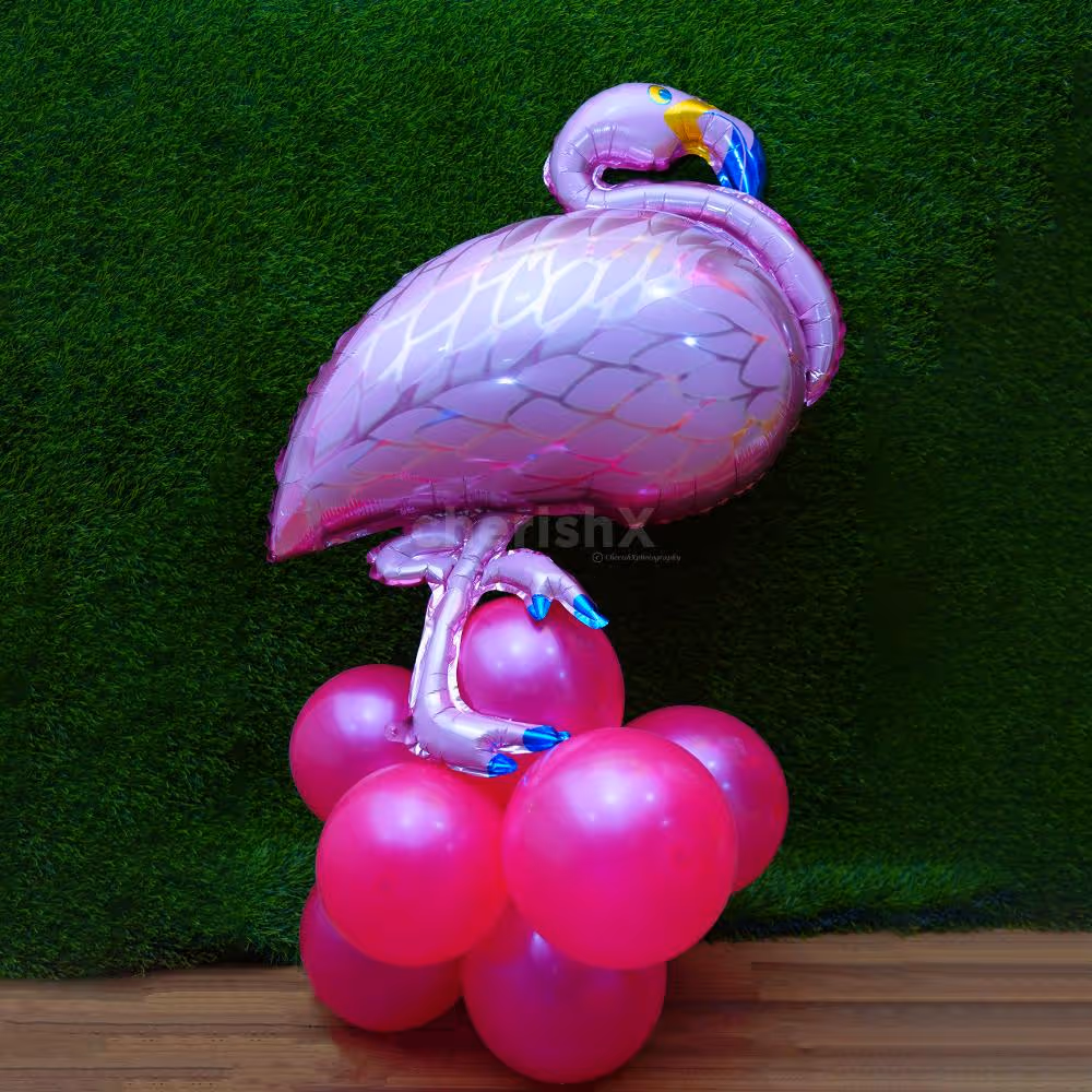 Delight in Juice Glass, Kiwi, and Flamingo Foil Balloons Amidst Palm Leaves.