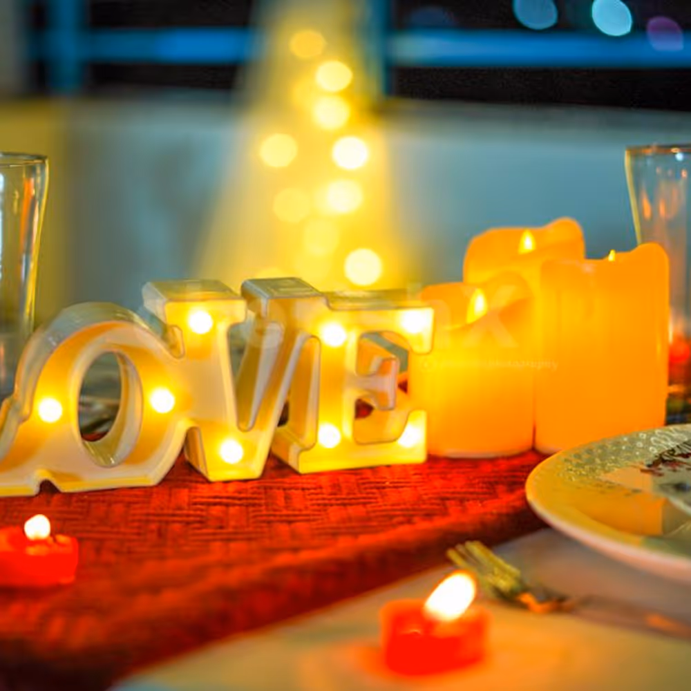 Candles and creative menus adorn the dinner table, setting the mood for an intimate and romantic dining affair.