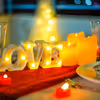 Candles and creative menus adorn the dinner table, setting the mood for an intimate and romantic dining affair.