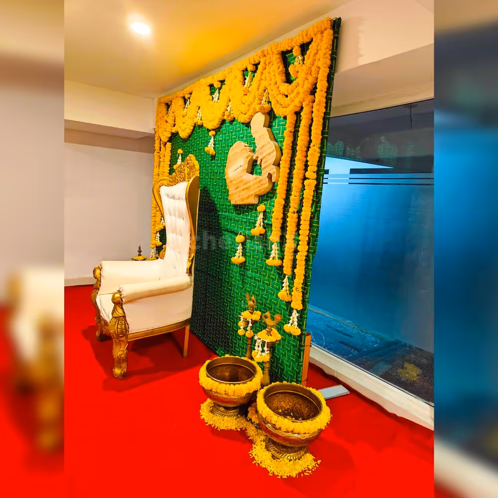Delicate marigold flowers adorn a Coconut leaf stand backdrop, creating a tranquil ambience for a baby shower celebration.