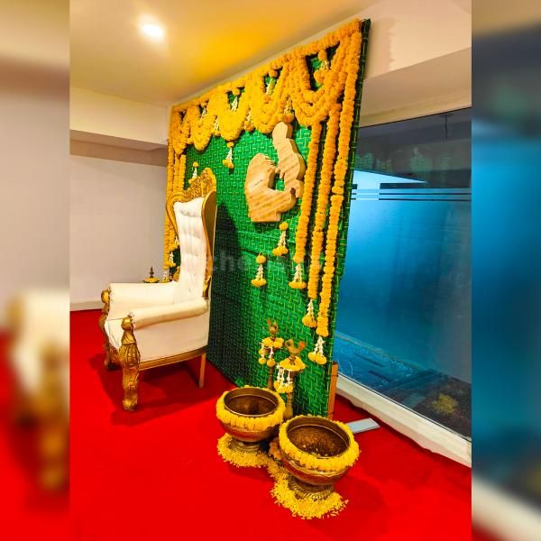 Delicate marigold flowers adorn a Coconut leaf stand backdrop, creating a tranquil ambience for a baby shower celebration.