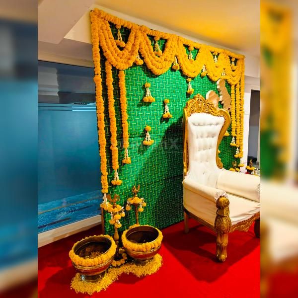 Delicate marigold flowers adorn a Coconut leaf stand backdrop, creating a tranquil ambience for a baby shower celebration.