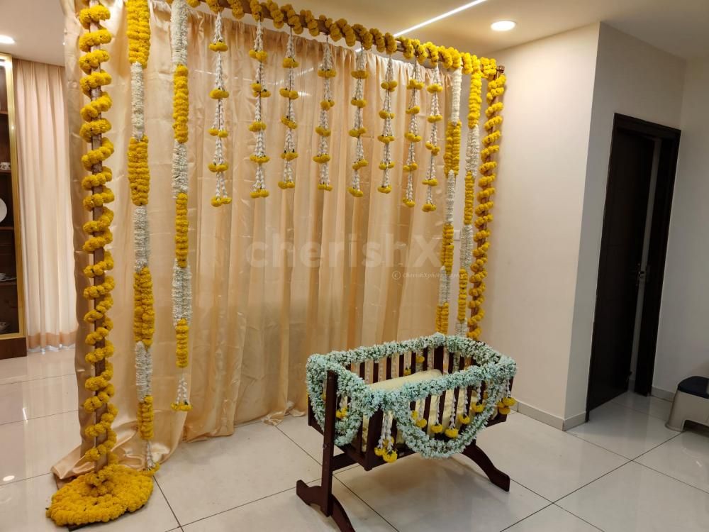 A gold-coloured backdrop adorned with 11 rows of marigold yellow and lily flowers, creates a captivating and visually striking centrepiece.