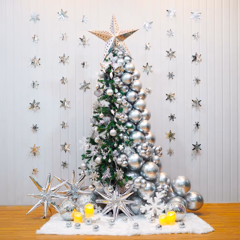 A beautiful Christmas tree decoration features a 6-ft non-pine tree decked out with silver chrome balloons, LED lights, and a silver paper star.