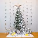 A beautiful Christmas tree decoration features a 6-ft non-pine tree decked out with silver chrome balloons, LED lights, and a silver paper star.
