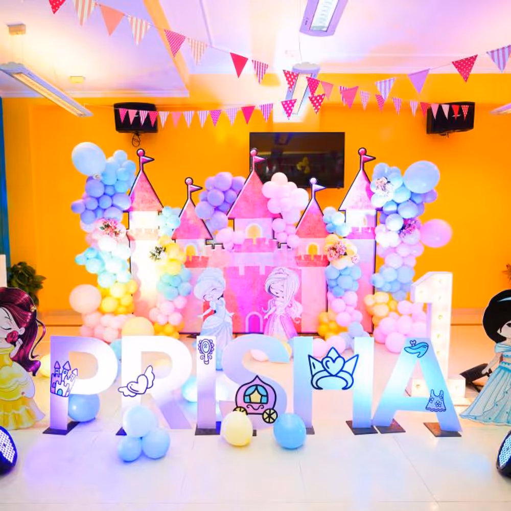 Our princess-themed decor features a captivating castle backdrop adorned with pastel balloons, creating an enchanting arch.