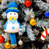 Golden snow cutouts, mirror balls, and a mix of festive decorations create a glittering display near the tree.