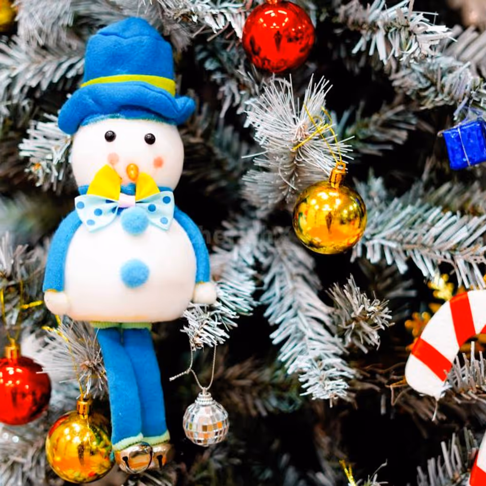 Golden snow cutouts, mirror balls, and a mix of festive decorations create a glittering display near the tree.
