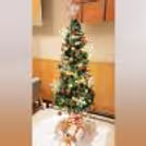 A festive Christmas tree adorned with gold and red ornaments, silver stars, and green moss, creates a magical Christmas vibe.